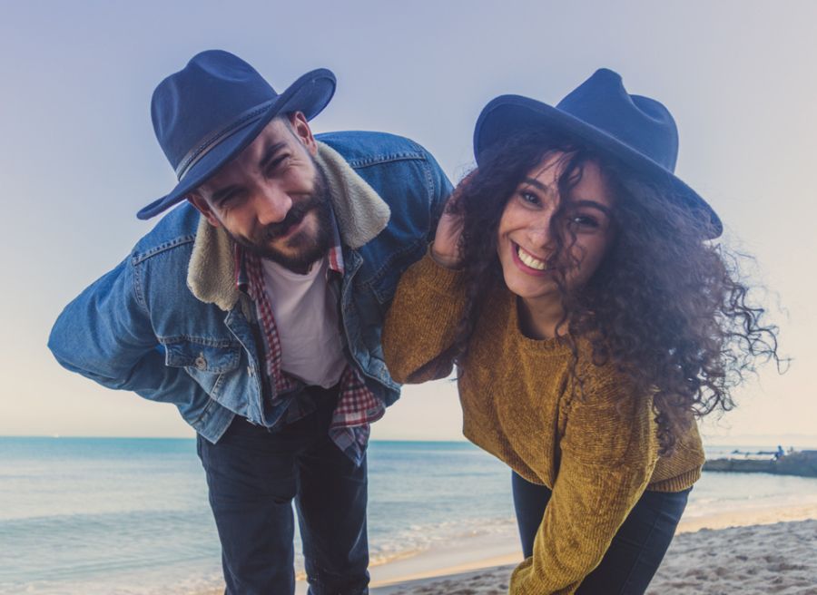Pareja con sombrero en la playa