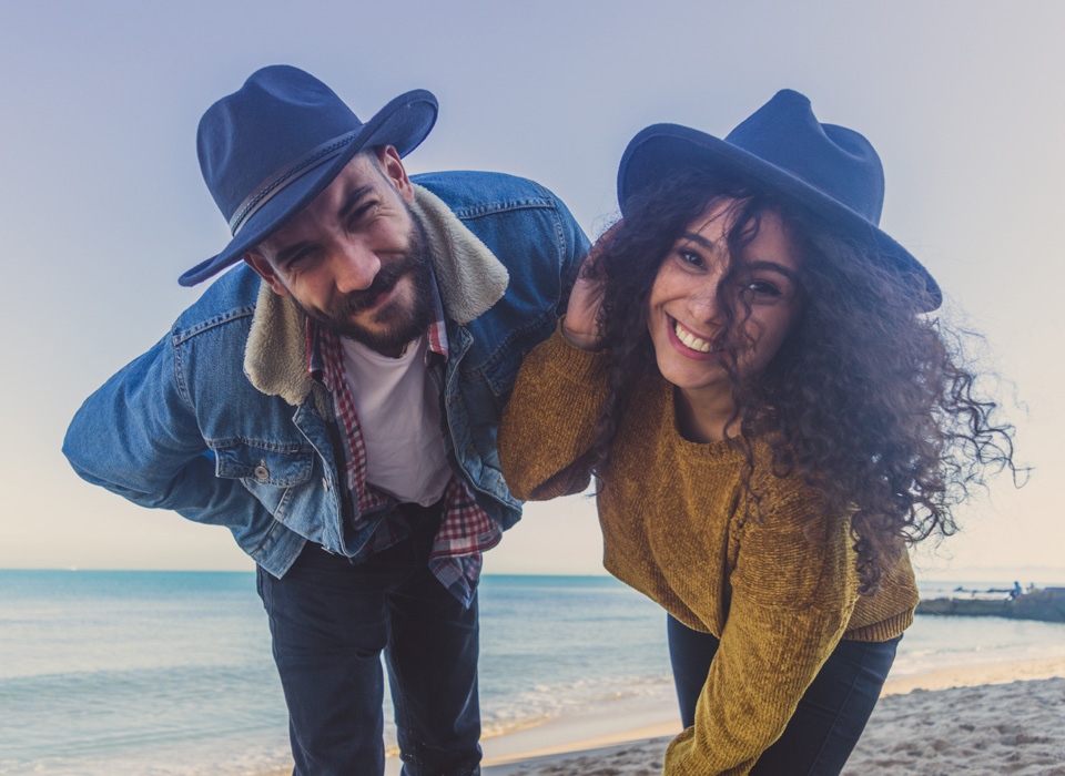 Pareja con sombrero en la playa